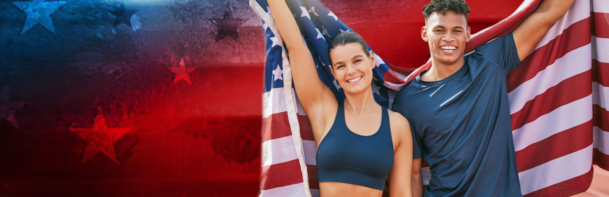 Two fit athletes in sportswear holding an American flag, smiling and celebrating against a dark textured background