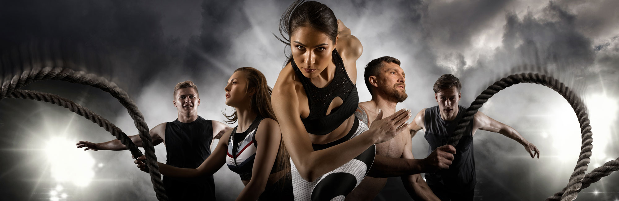 A group of athletes engaged in intense multi-sport training, featuring battle ropes and sprinting. The dynamic scene represents strength, endurance, and versatility in sports performance, ideal for training on high-quality synthetic turf surfaces
