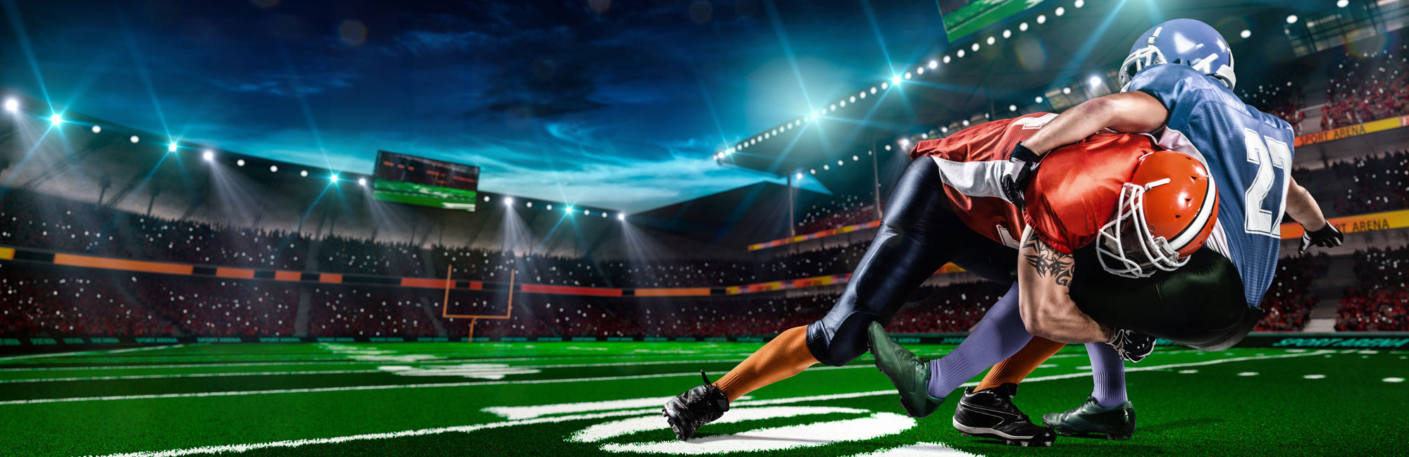 Intense football tackle under stadium lights on a vibrant synthetic turf field, highlighting power, competition, and athleticism.