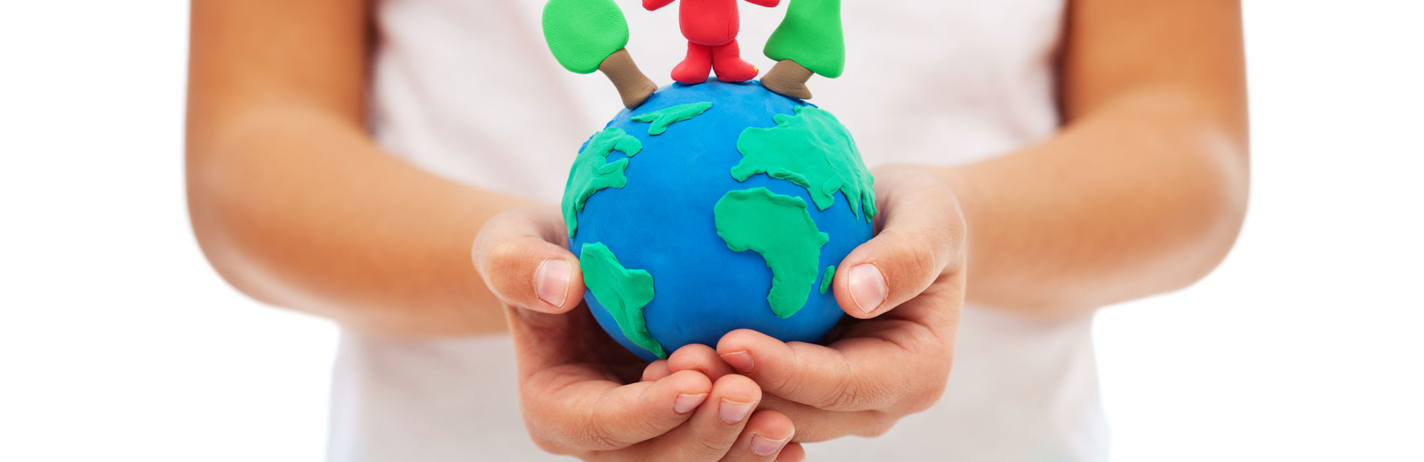A child holding a small globe with sprouting plants, symbolizing environmental responsibility and sustainability.