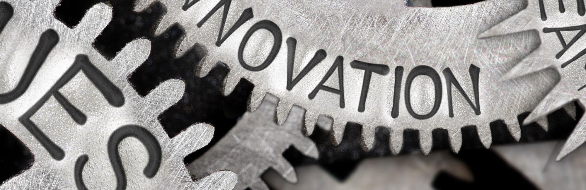 A macro shot of interlocking metal gears with the word INNOVATION engraved, representing progress and technological advancement.