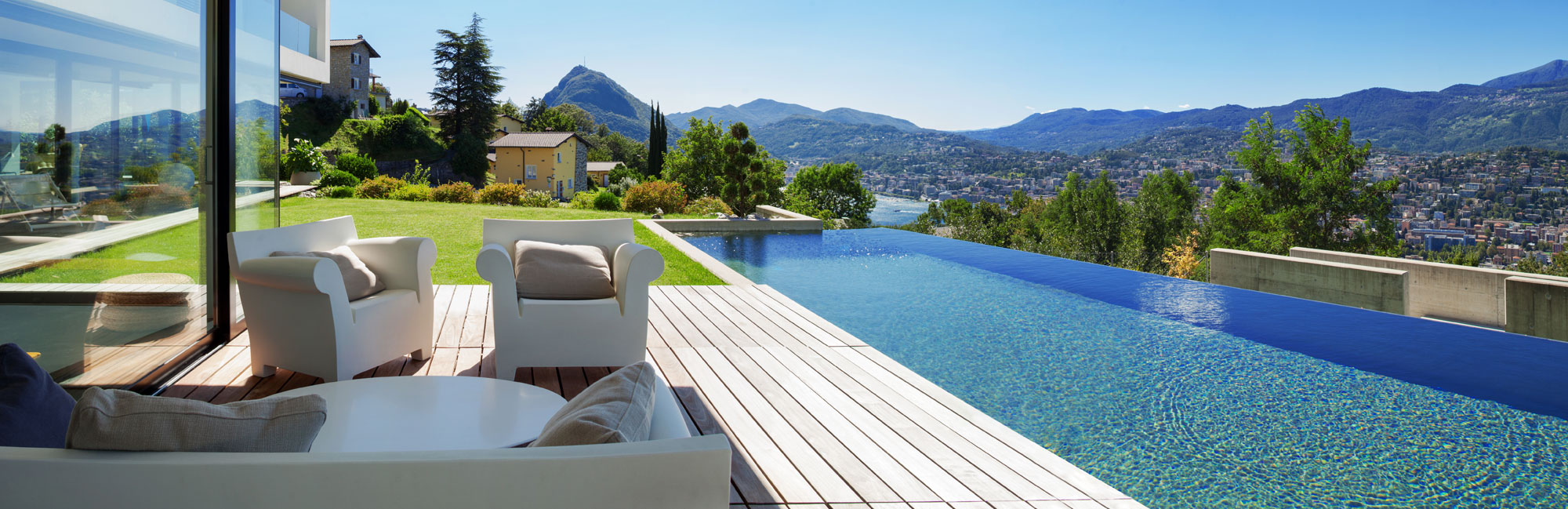 Luxury outdoor space featuring an infinity pool with a breathtaking mountain view and modern patio furniture.