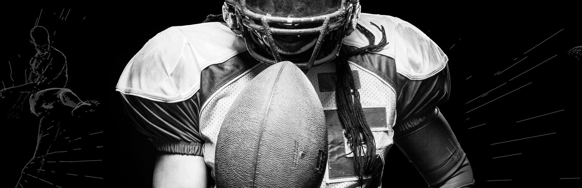 Black and white close-up of an American football player in full gear holding a ball. The dramatic contrast emphasizes strength, determination, and the role of high-quality synthetic turf in professional football games