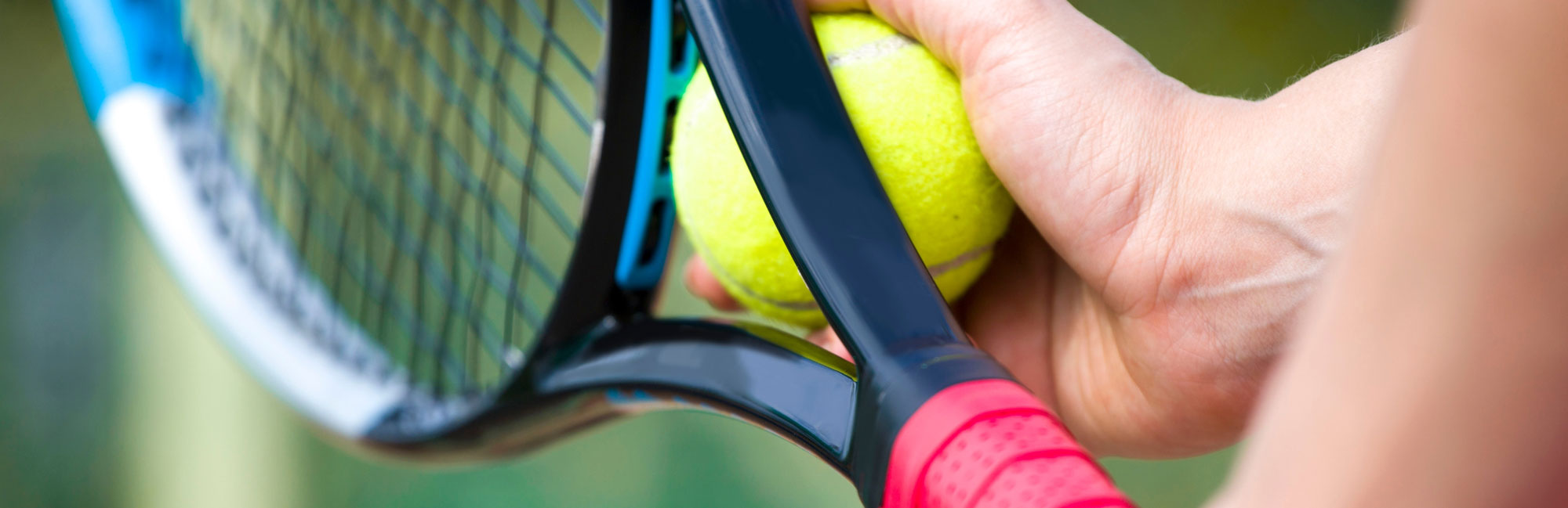 Tennis player adjusting their grip on a racket before a match.